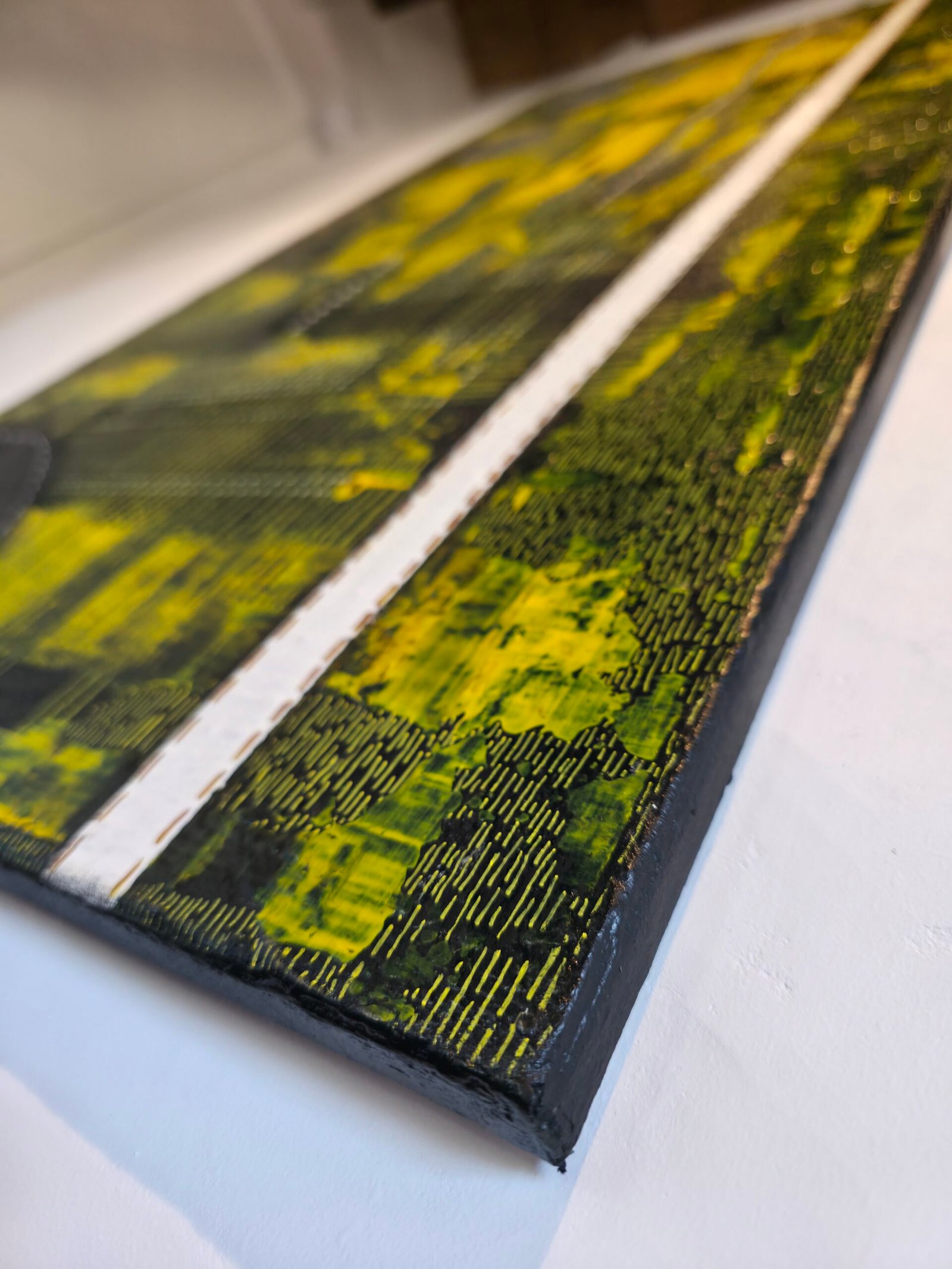 Détail macro de l'œuvre Ligne brisée dans la nuit par Chatti Karim. Zoom sur les reliefs de peinture jaune et or traversés par une ligne blanche. Vue latérale de l'épaisseur du châssis 3D. Art contemporain abstrait, collection L'Invisible.